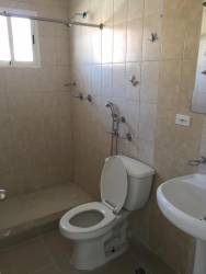 Bathroom with pedestal sink, tiled walls and walk-in shower at West Village Residence Panama