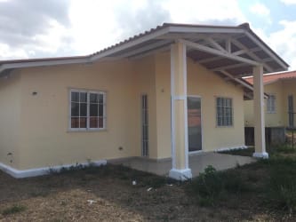 Yellow house with covered porch and gable roof in West Village Arraiján Panama for sale