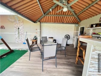 Covered outdoor entertainment patio with bar counter and ceiling fans in Nuevo Emperador