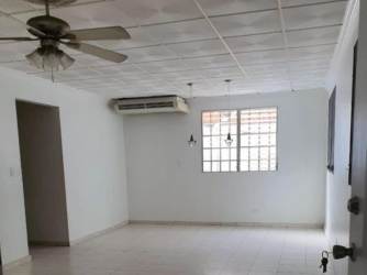 Covered corridor exterior, blue painted wall, iron security door, protected walkway La Chorrera