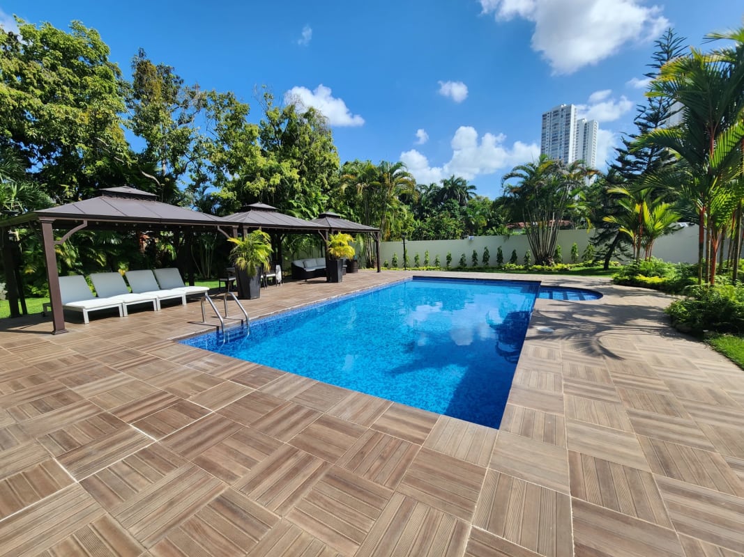 Lush landscaped garden with tall trees and tropical plants on luxury property for sale in Altos del Golf Panama