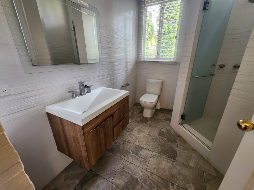 Elegant bathroom with floating vanity, large mirror, glass shower in Panama luxury estate