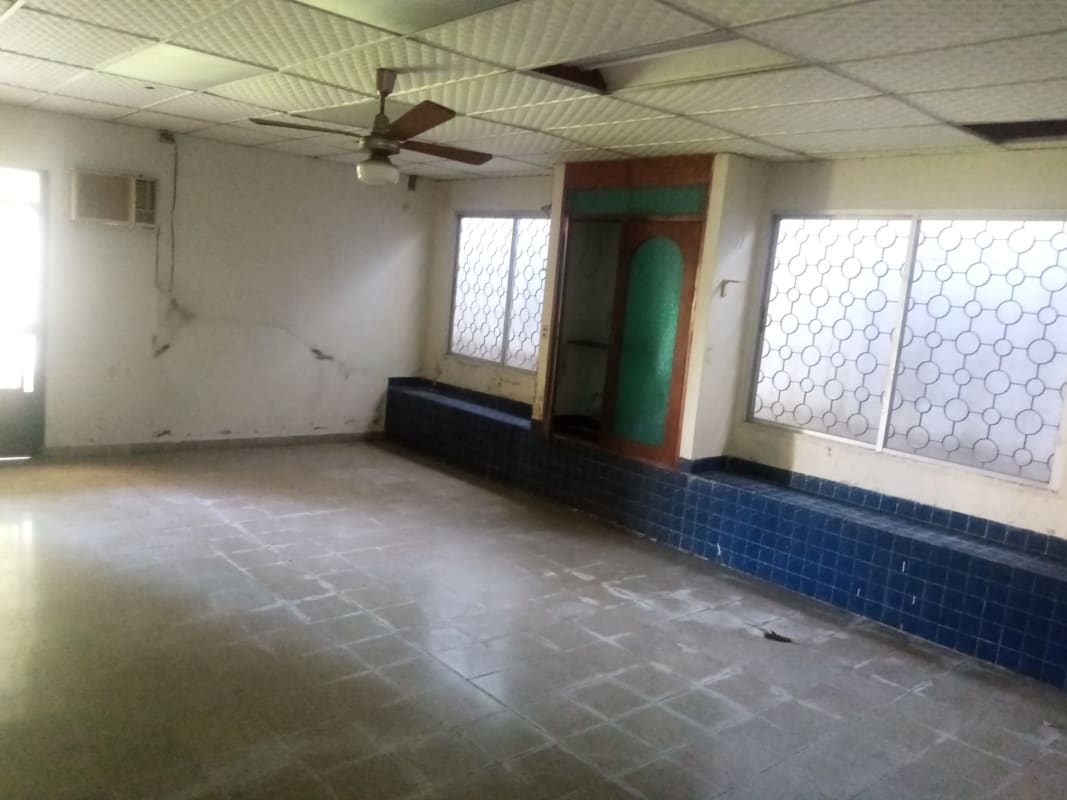 Spacious landscaped backyard with green lawns and tropical trees Altos del Golf