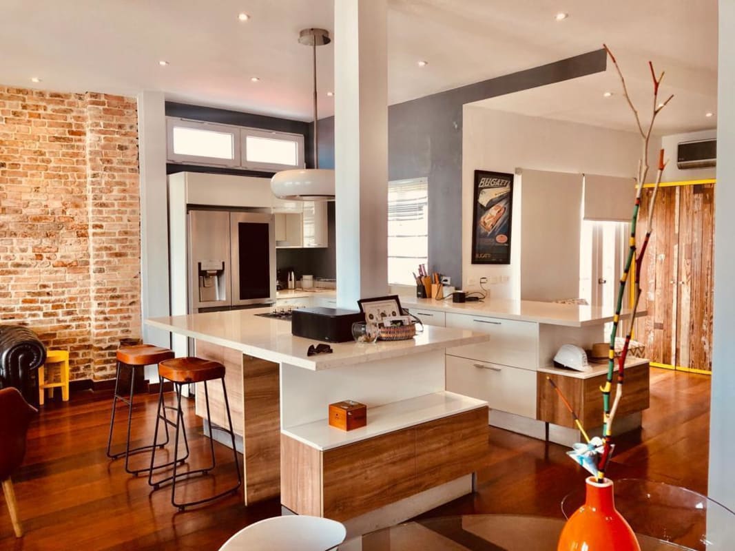 Bedroom with TV, AC unit and wooden floor in Casa Jeronimo Casco Viejo Panama