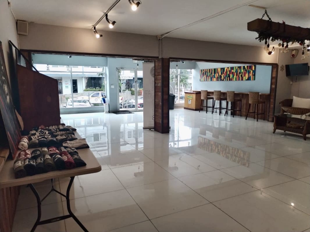 Open layout commercial space with large windows, modern light fixtures and white tiled floors suitable for retail or events