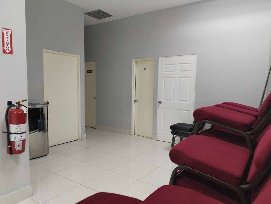 Contemporary lobby area with wooden wall accents, wicker seating, paintings and modern lighting in commercial center Obarrio Panama