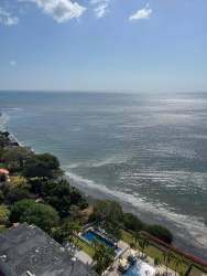 Infinity pool facing Pacific Ocean with sunbathing area at El Palmar Residences San Carlos Panama
