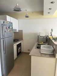 Modern living room with TV and large window beachfront condo at El Palmar Panama