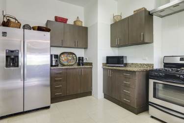 Contemporary kitchen with granite countertops, stainless appliances in Hacienda Pacifica villa