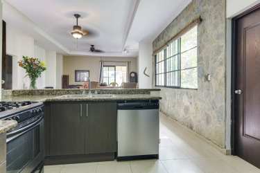 Bright open plan living area with large windows overlooking tropical gardens in Coronado villa