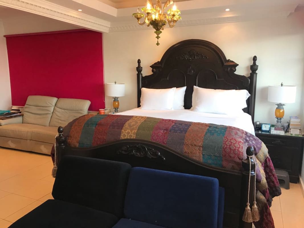 Traditional bedroom with chandelier and wooden bed frame in Dos Mares Panama
