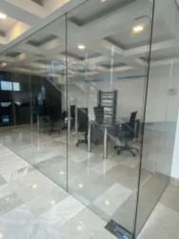 Bright glass-walled private office with marble tile and modern furniture at Grand Plaza Panama