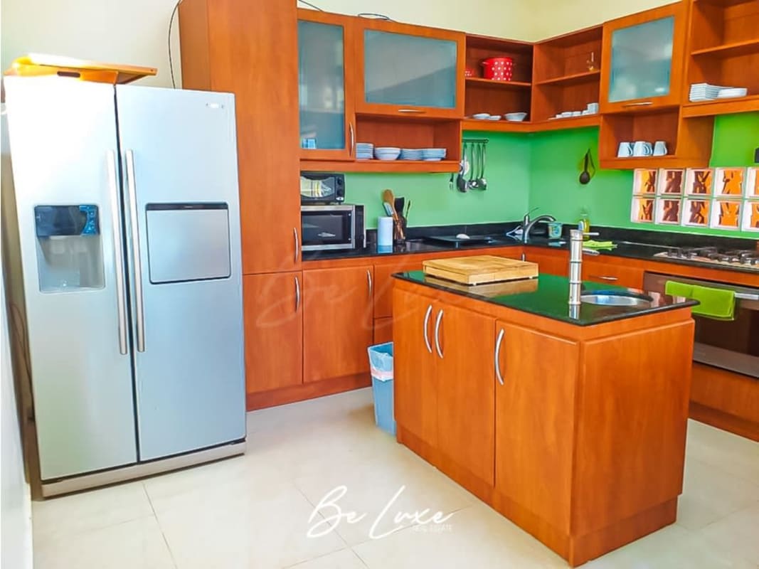 Spacious kitchen with island, wood cabinetry, and full appliances Isla Saboga villa Panama