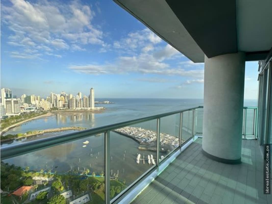 Private balcony with glass railings facing ocean and city skyline at PH Yacht Club Avenida Balboa Panama