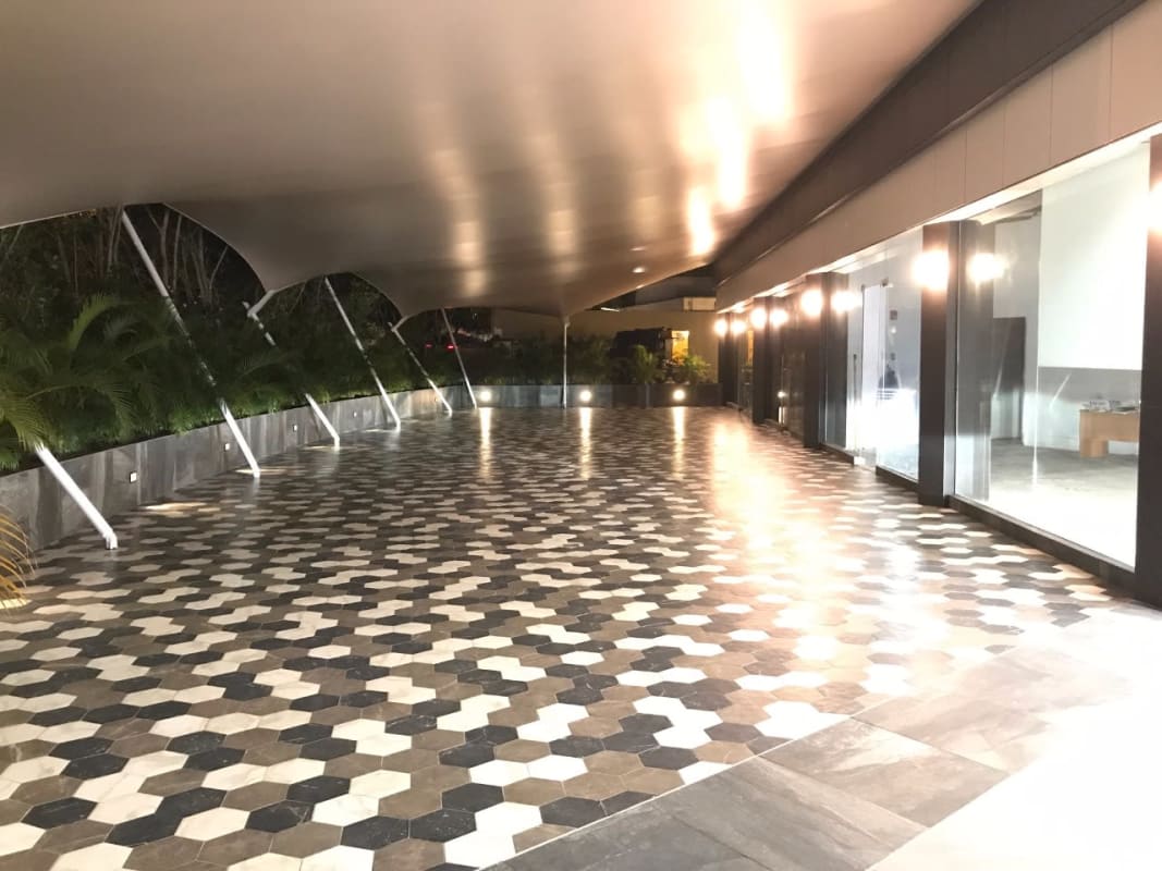 Contemporary covered terrace with hexagonal tile flooring and tropical landscaping at Plaza Santa Elena Panama City