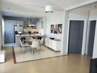 Bright living room with vaulted ceiling, sofa set, dining area, tile floors in PH Ibiza Beach Residences Rio Hato Panama