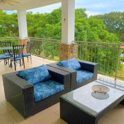 Balcony with outdoor dining overlooking tropical garden and pool Punta Barco Village Panama