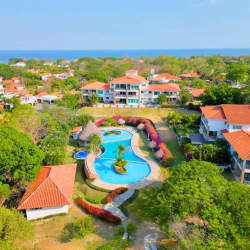 Bedroom with large balcony window bright light white furniture blue accents Punta Barco Panama