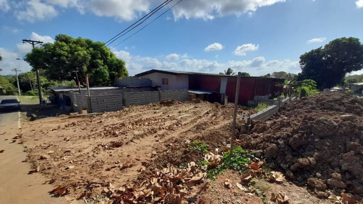 Vacant fenced commercial land with banana plants, tree shade, and blue shipping container Chepo Panama