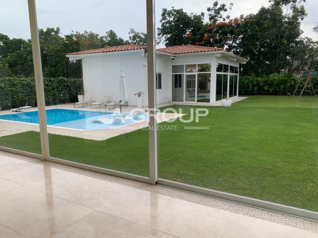 Spacious living room with floor-to-ceiling windows overlooking garden and pool, luxury estate Panama City