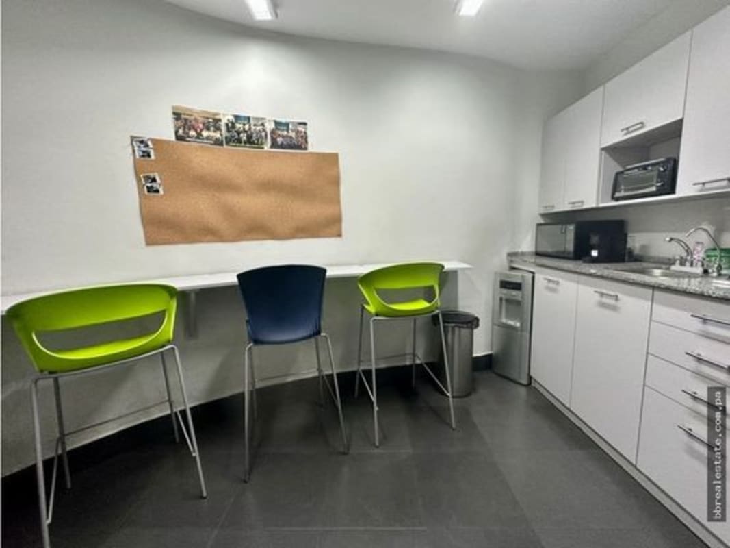 Office kitchenette with bar stools, countertop, and appliances in Torre de las Américas Panama