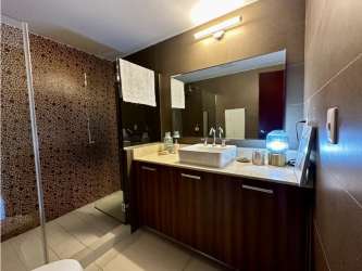 Bathroom with vessel sink, glass shower enclosure, modern tiles PH River Valley Panama Pacifico