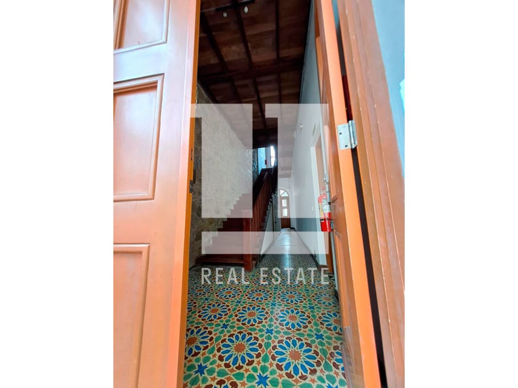 Decorative floor tile entry and stone wall with wooden stairs colonial building Casco Viejo Panama