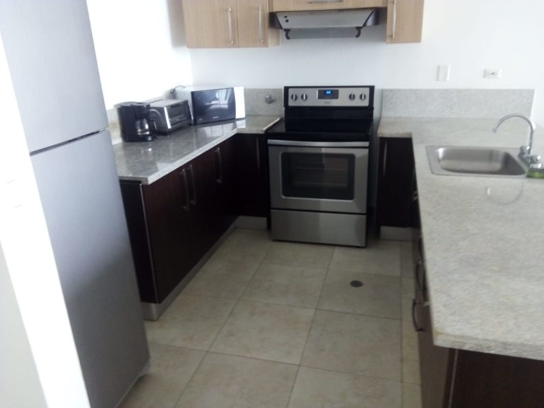 Modern kitchen with granite countertops, appliances and cabinetry at PH H2O On The Ocean Panama City