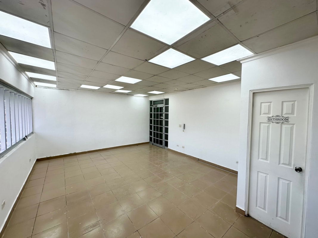 Office unit with window, tiled floor, white walls, and bathroom door Plaza La Bonanza Betania Panama