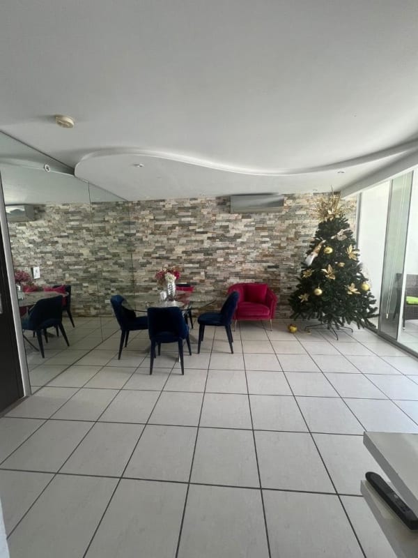 Living and dining room with accent wall, large mirror and glass doors to balcony in PH Lefevre 75 Panama City