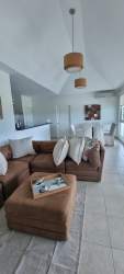 Living room with vaulted ceiling, large windows, open concept at Bijao Beach Condo Panama