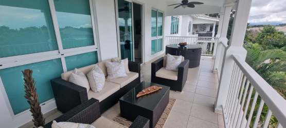 Covered outdoor balcony with dining and lounge furniture pool view Bijao Panama