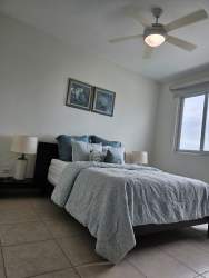 Bedroom with queen bed, AC, ceiling fan, balcony access at Bijao Beach Condo Panama