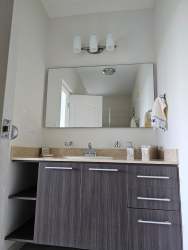 Modern bathroom with double sink, mirror at Bijao Beach Condo Panama