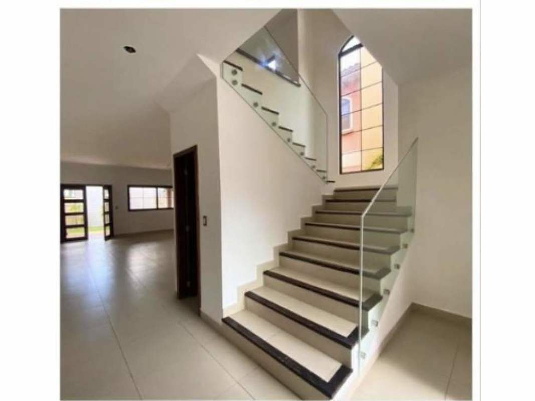 Two-story Mediterranean house with arched windows, terracotta facade, tile roof, landscaped yard in El Doral Costa Sur