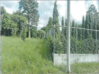 Vacant fenced lot with lush green grass and mature trees Quebradas de Cabuya Chame Panama