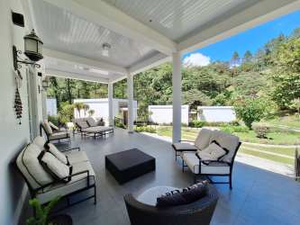 Spacious covered patio with seating overlooking lush garden and forest in Panama mountain property