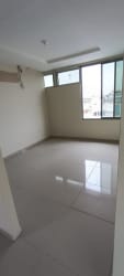 Modern tiled living area with large windows inside multi-level building Chitre Panama