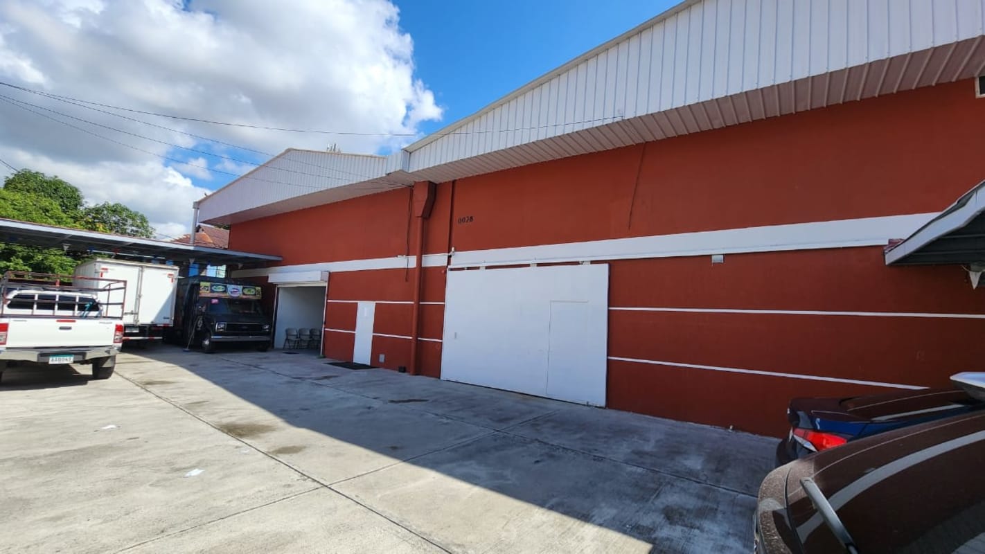 Exterior of industrial warehouse with parking and truck loading access in Panama City