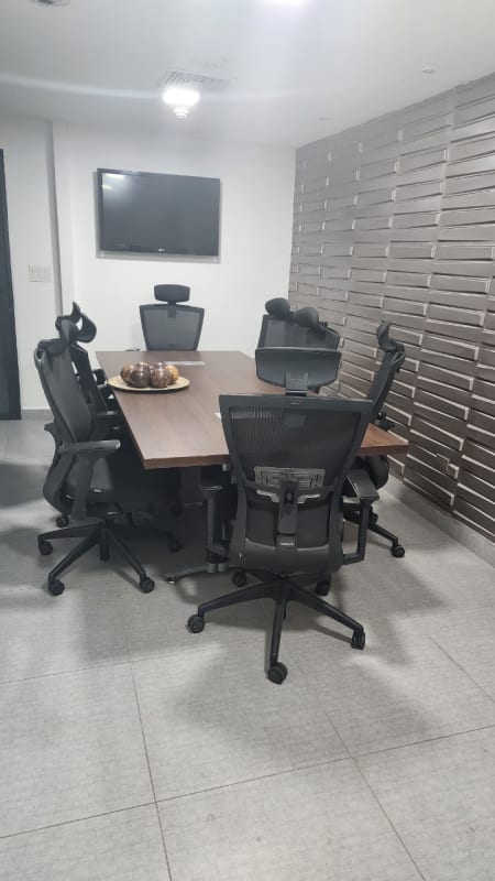 Conference room with large table, chairs and mounted TV inside warehouse office in Panama