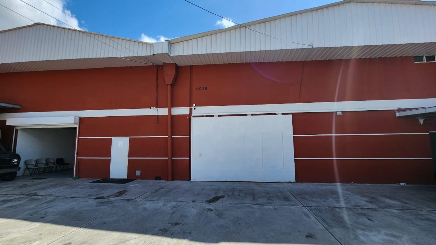 Facade of industrial warehouse with large access doors and concrete plaza Rio Abajo Panama