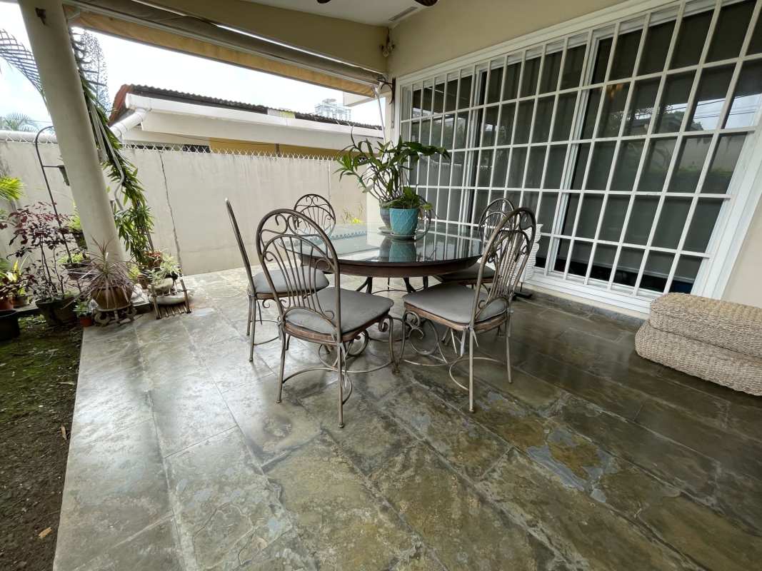 Large living and dining room with marble floors and wood beams in luxury house Altos del Golf Panama City