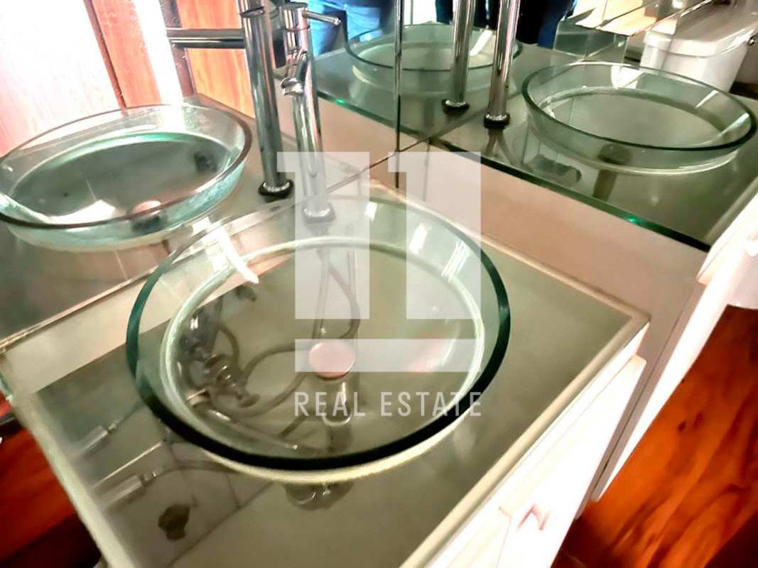 Modern bathroom with double glass vessel sinks and mirrored backsplash Balboa Plaza Panama