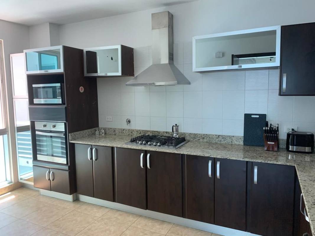 Fully equipped modern kitchen with granite countertops and stainless steel appliances in PH Titanium Costa del Este Panama
