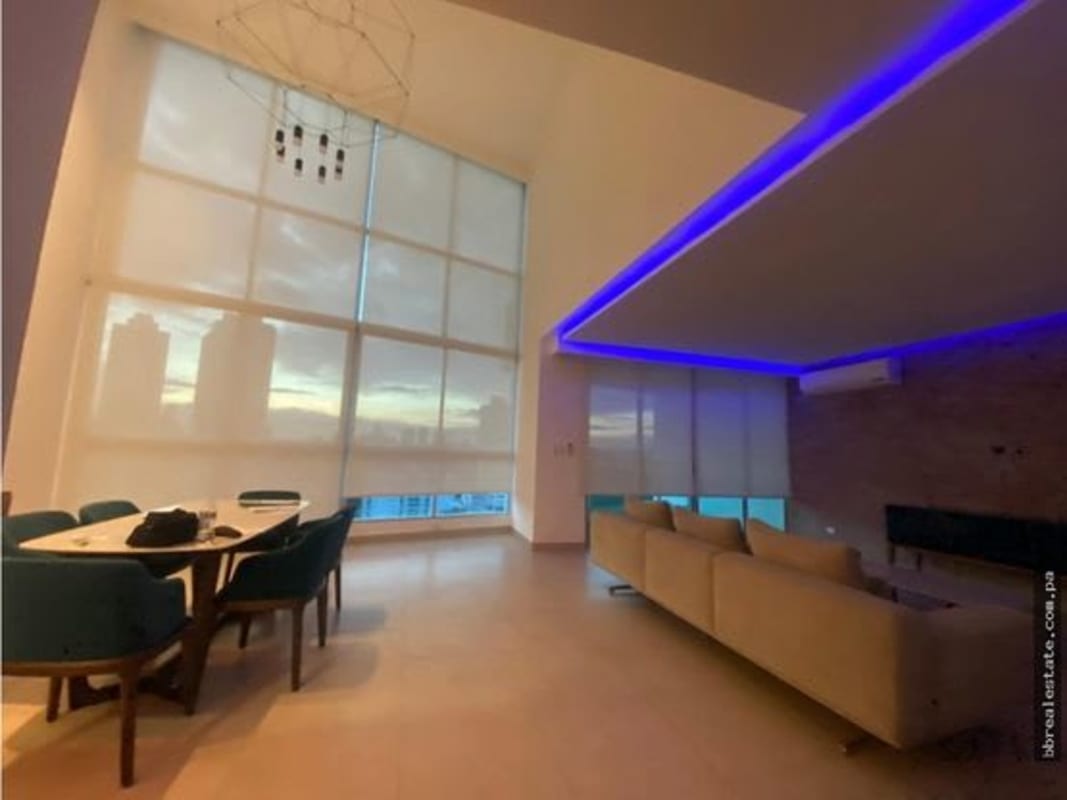 Open-plan living and dining area with floor-to-ceiling windows city view PH Park Loft Panama