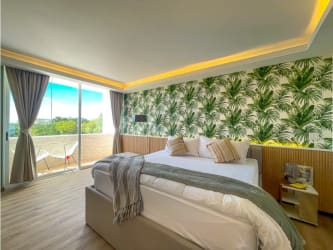 Studio bedroom with balcony, king bed, tropical wallpaper Playa Blanca Resort Panama