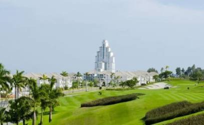 Golf greens and modern condominium buildings within Bijao Beach Club & Residences Río Hato, Panama