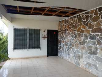 Covered parking area with stone accent wall and greenery at commercial lot La Villa de Los Santos Panama