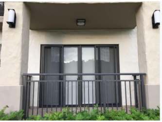Bright living room PH River Valley with sliding glass doors leading to balcony overlooking gardens in Panama Pacifico