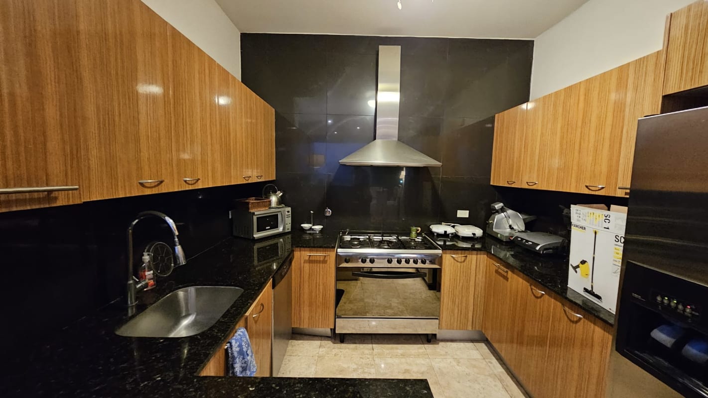 Contemporary kitchen with wood cabinets, granite countertop, stainless steel appliances in PH Sky Residence Avenida Balboa